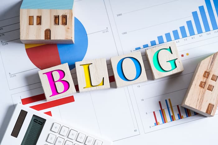BLOGの文字が書かれた木のブロックや資料が置かれている